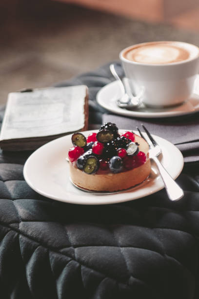 Coffee Break with old open Book and Berry Tart