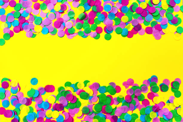 Multicolored confetti on a yellow background. Festive concept