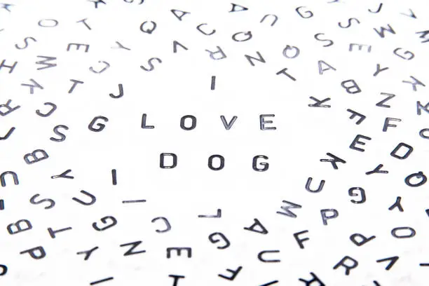 I love dog word written with text only with black letters top down far away shot in a puzzle of alphabets