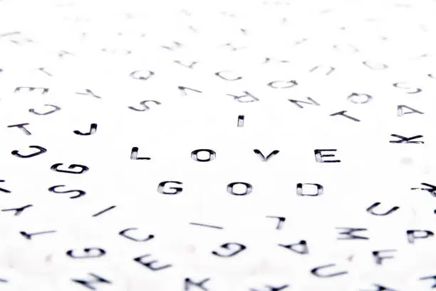 I love GOD word written with black letters macro/close up top down shot in a puzzle of alphabets