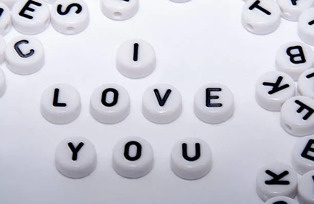 I love you word written with white buttons/dice with letters close up shot