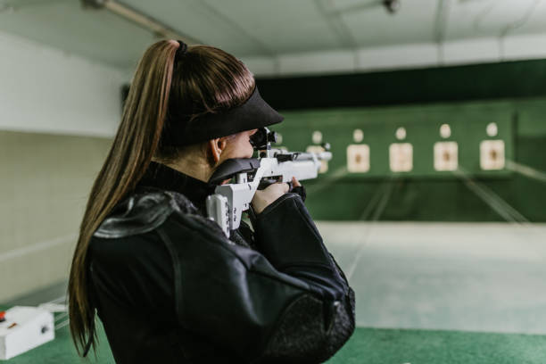 Shooting range Shooting range. Young woman practicing shooting in a modern indoor shooting range. female sharp shooter stock pictures, royalty-free photos & images