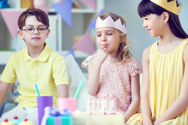 istock Little girl tasting cake having birthday celebration 1151611250