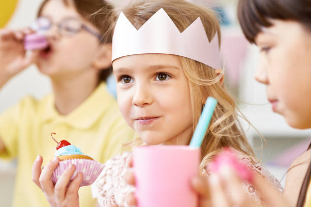 istock Cute girl in crown eating cupcake 1151611321
