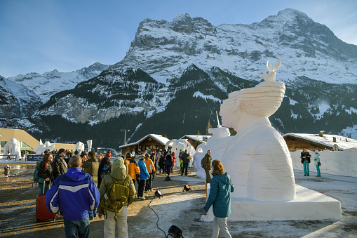 Grindelwald, Switzerland - January 26, 2019: People looking at ice statuses during Snow Festival in Grindelwald, Switzerland in January 2019