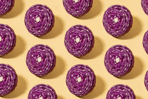 Half Sliced Red Cabbage Pattern on Yellow Background Half sliced red cabbage fruit in a row on yellow background healthy eating red above studio shot stock pictures, royalty-free photos & images