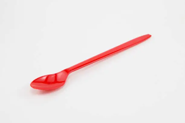 Photo of Red plastic spoon on white background