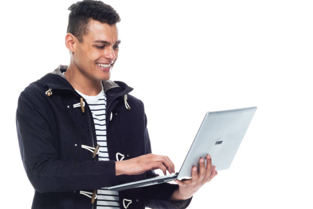 istock Handsome African American male standing on white background - using a laptop 1151614761