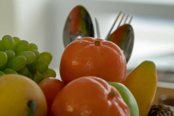 Many kinds of fruit piles with a spoon and fork in the back