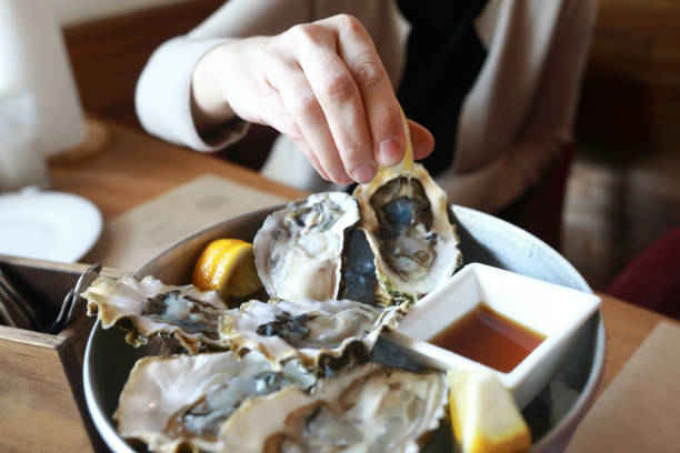 istock Person squeezes lemon juice on oysters 1151616666