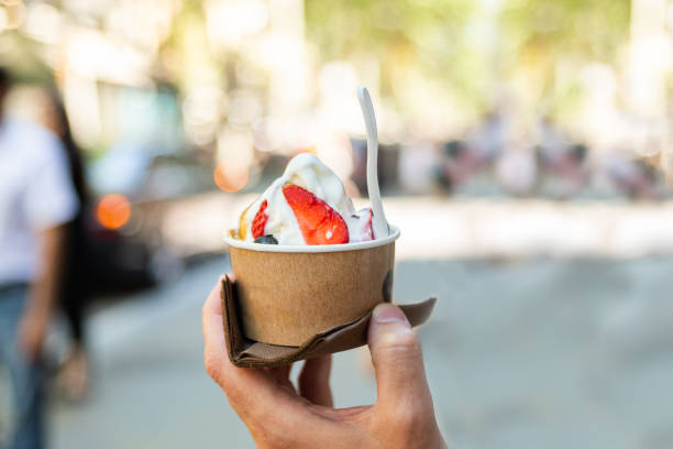 istock Hand holding paper cup with ice cream on blurred backgruond 1151616802