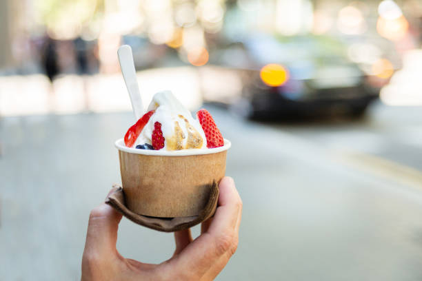 istock Hand holding paper cup with ice cream on blurred backgruond 1151616806