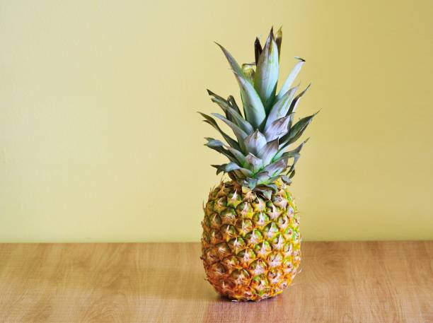 istock Pineapple on a wooden table.Copy space. 1151618114
