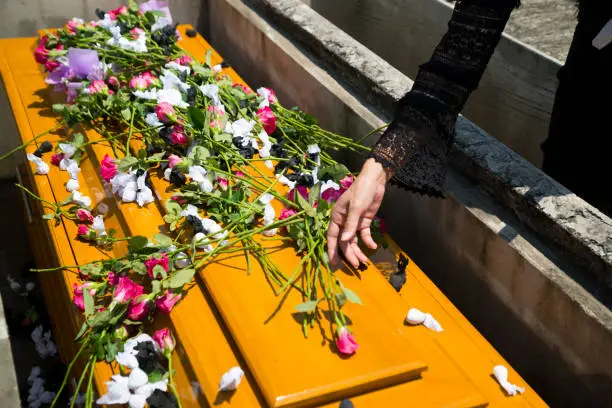 Photo of Hands of women Holding a rose, Put on the coffin.