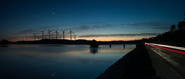 Windmills in the sunset. Wind turbines motion landscape at sunset with plane in background