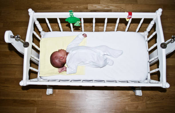 Baby in a wooden white cot