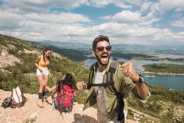 istock Ecstatic young man hiking with friends. 1151625758