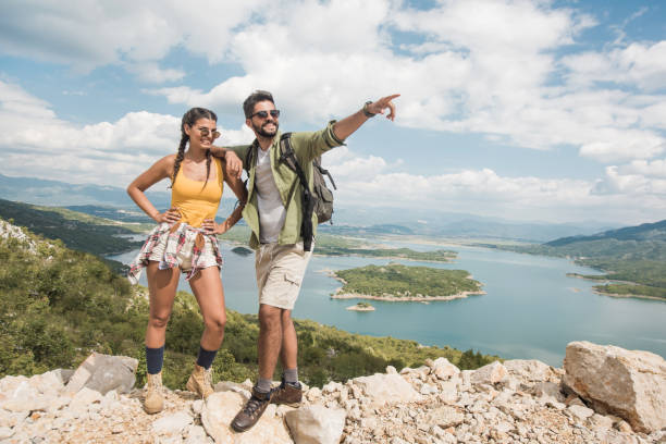 Happy young couple taking a break from hiking on a beautiful view.