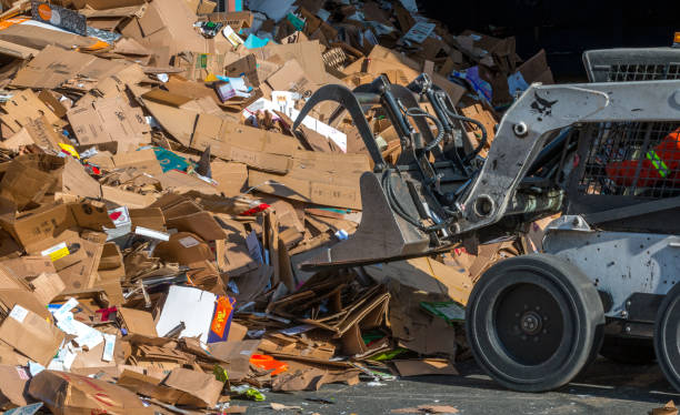victoria , British Columbia/ Canada : 04/30/2019. A Bobcat operator piles cardboard for recycling.