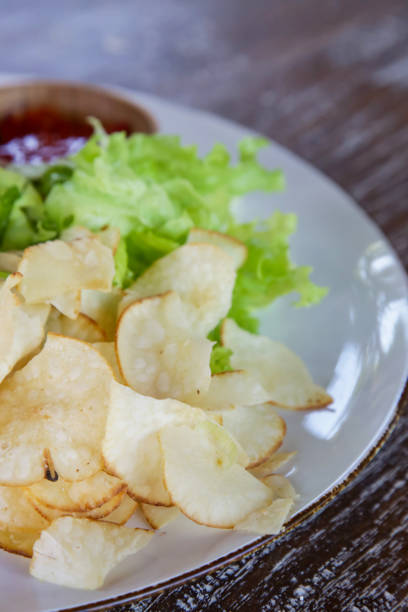 istock Chips and green salad on the plate 1151627551