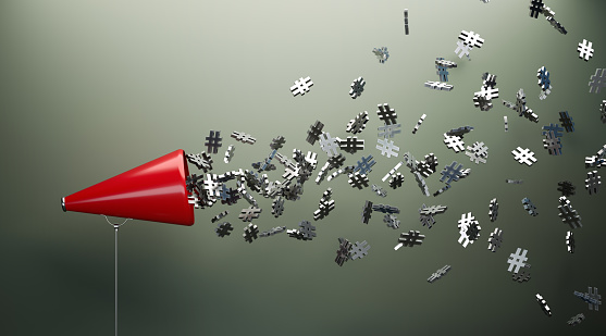 Red Megaphone And Silver Hashtag Symbols In Front Of Gray Wall