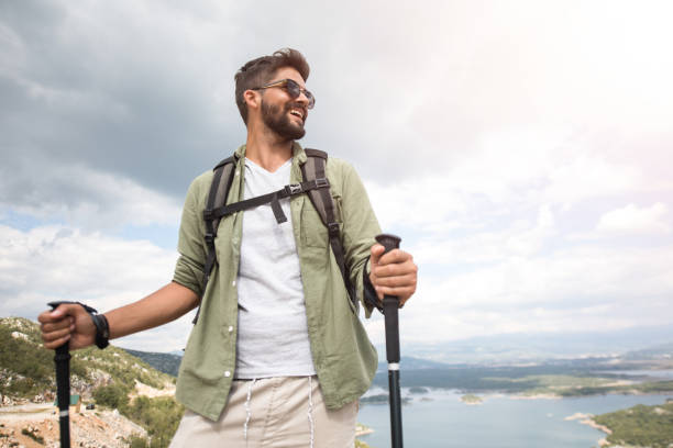 istock Low angle view of happy young man hiking on a beautiful view. 1151630692