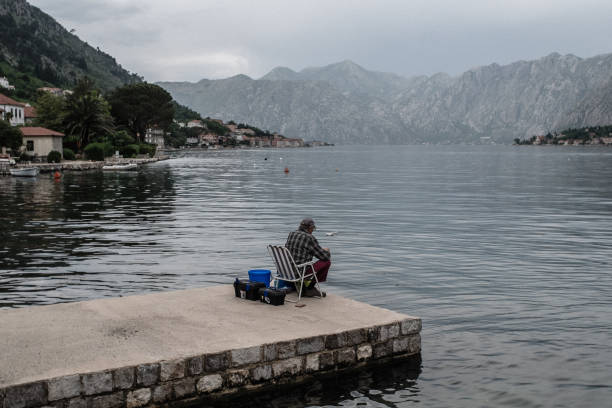 Fisherman sitting on a chair, in Kotor Bay in Montenegro.