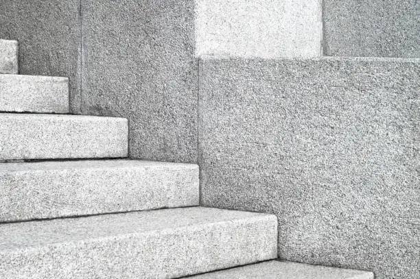 The edges and corners of the stone granite stairs. Concrete architecture fragments close up.