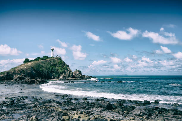 istock Blue ocean waves sweeping towards the rocky coast background the lighthouse on mountain. 1151639031