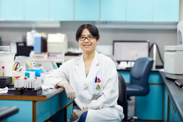 istock Smiling female researcher sitting by desk 1151640494