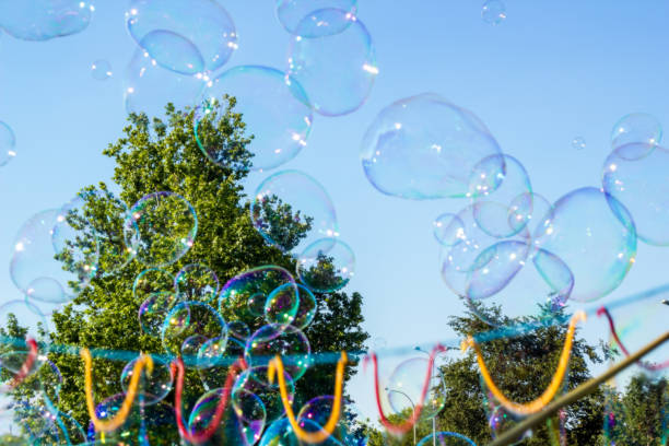 istock Blurred big soap bubbles flying in blue sky, abstract background 1151640946