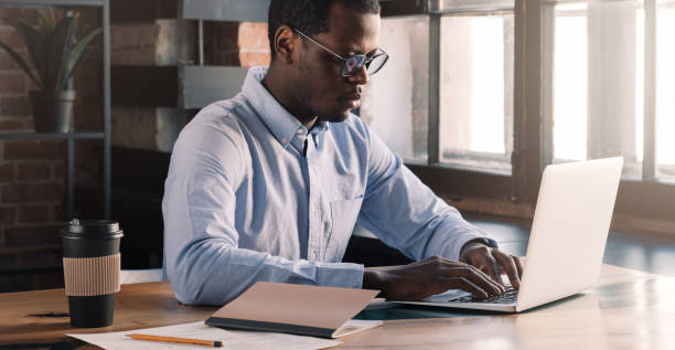 istock Modern african man using laptop in modern loft office 1151641774