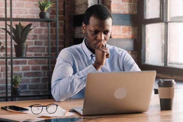 istock Serious african business man working on project at modern loft office, thinking about financial troubles 1151641779