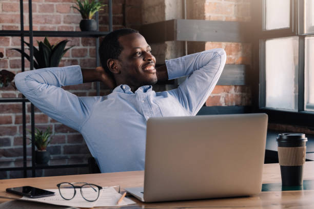 istock African man spending daytime in cafe with laptop open in relaxed pose, looking through window 1151641786