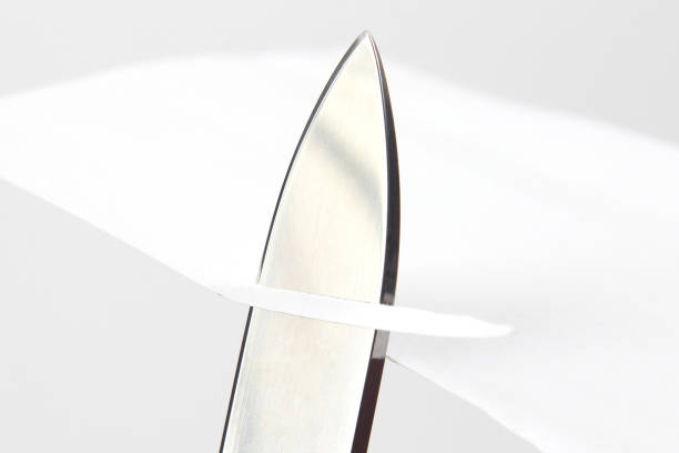 istock blade of a sharp knife cut across the white paper 1151642691