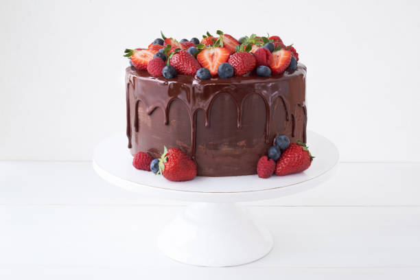 istock Cake with chocolate, decorated with various berries on a white table. 1151647217