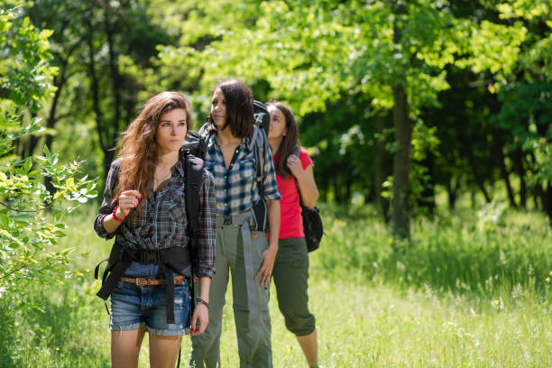 istock Three female tourists in forest with backpacks 1151655008