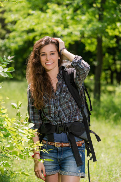 istock Happy girl tourist with backpack in forest 1151655605