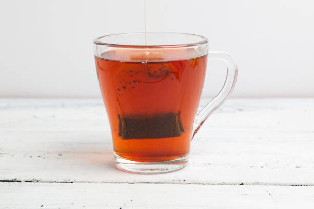 istock glass cup with tea bag on white table 1151658323