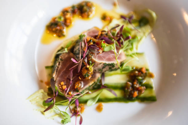 istock seared tuna with sauce and herbs on a white plate 1151659523