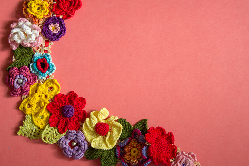 The necklace of crocheted flowers lies on paper, on the right is a free place.