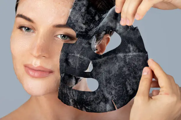 Photo of Woman removing bubble sheet mask from her face