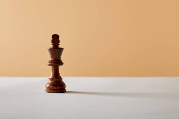 istock wooden king piece on white table and beige background 1151664139