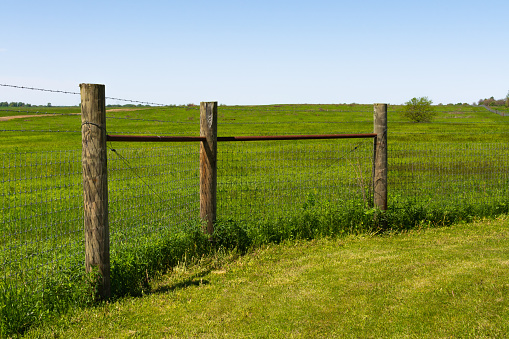 Wooden fence post with prairie in background.  Midewin National Tallgrass Prairie, Wilmington, Illinois