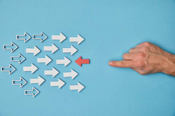 istock cropped view of man pointing with finger to red horizontal pointer opposite white arrows on blue background 1151668455