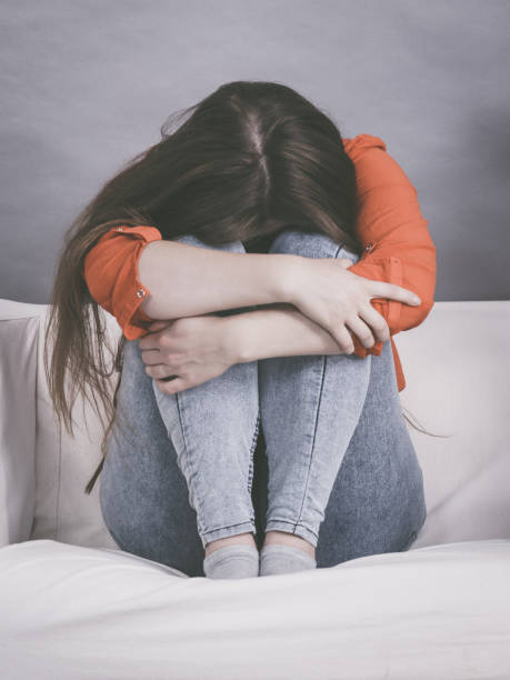 istock Worried woman sitting on sofa 1151669577