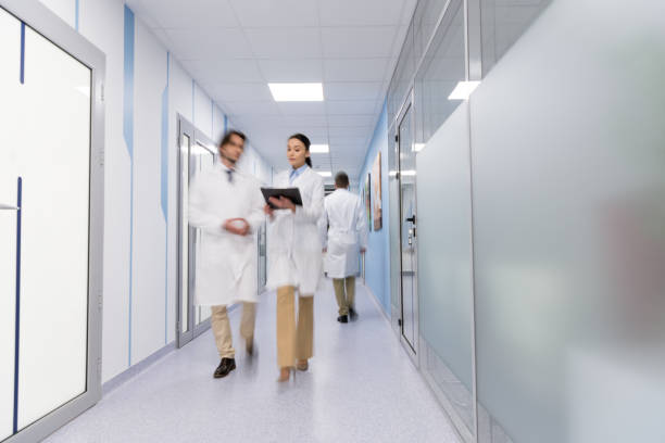 istock Doctors in white coats with black folder walking down hall 1151672438