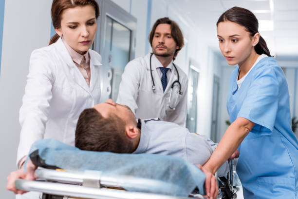 istock Doctors and nurse transporting unconscious patient on gurney 1151672449