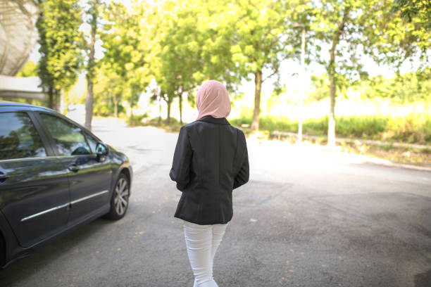 istock Young beautiful lady with hijab walking to car 1151676196