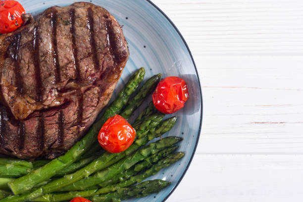 istock Grilled beef steak ribeye with cherry tomatoes and asparagus 1151678466